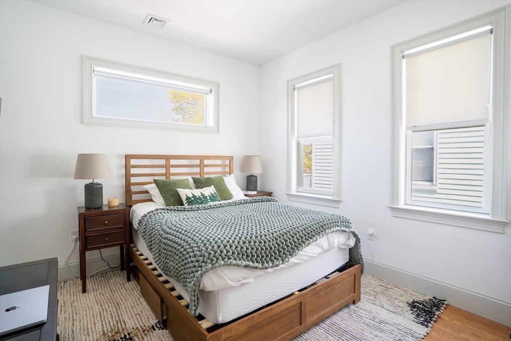 16 Church Street Boston, MA 02122 - Photo 16 of 23 a bedroom with a bed and wooden floor