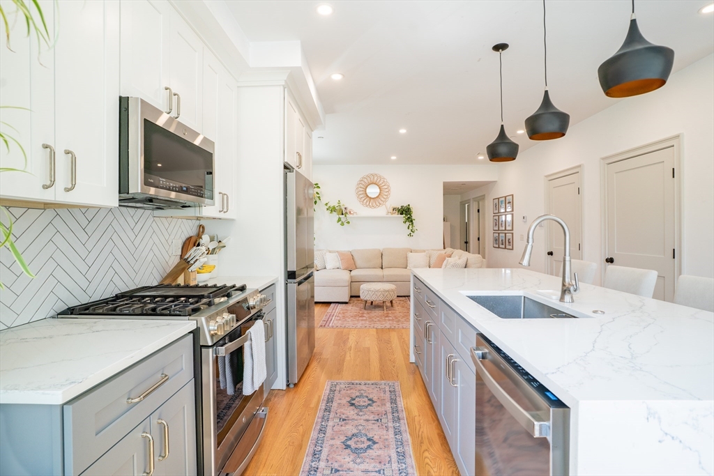 16 Church Street Boston, MA 02122 - Photo 2 of 23 a kitchen with a sink stainless steel appliances and a chandelier