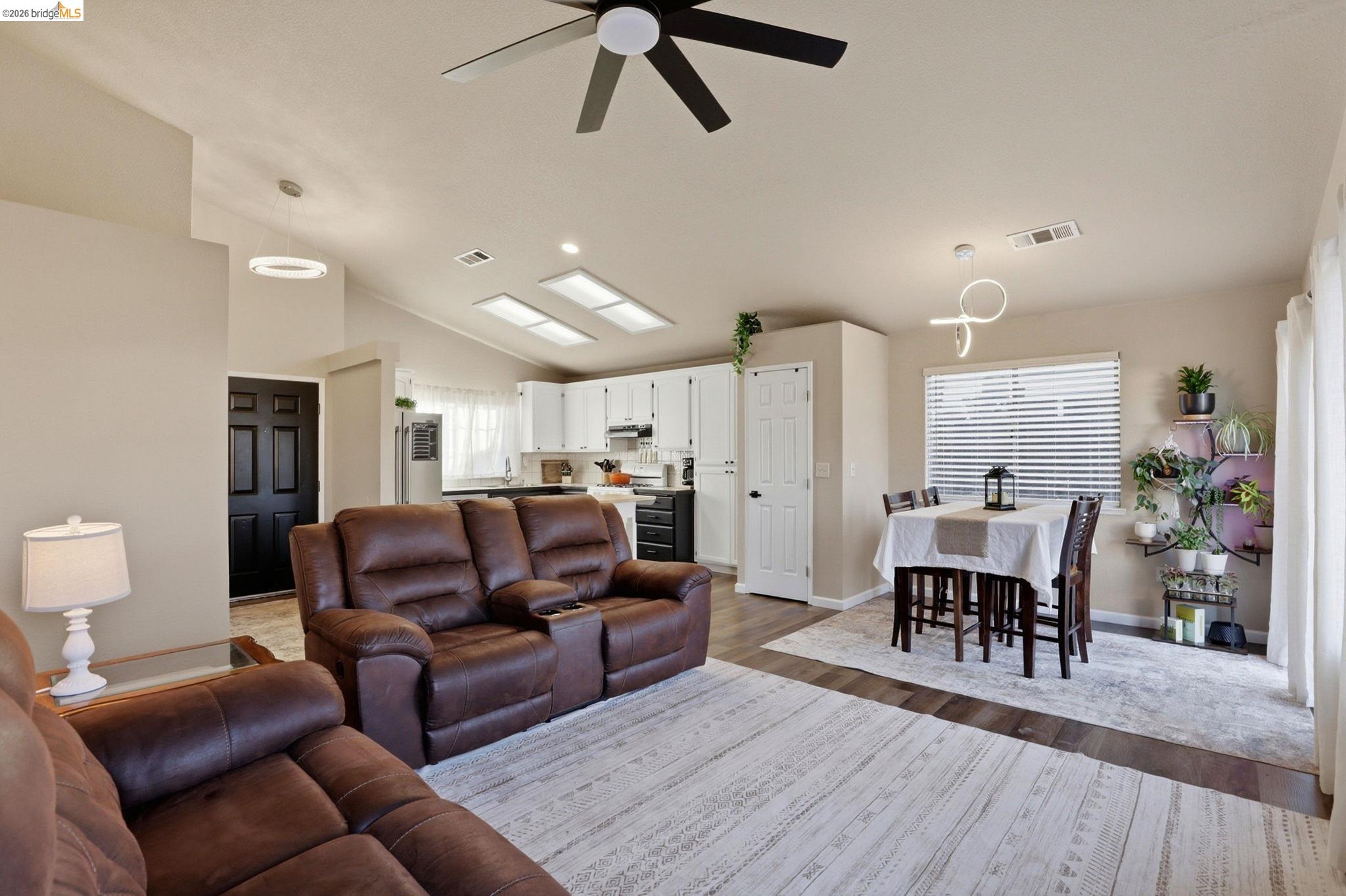 799 Morgans Ranch Circle Galt, CA 95632 - Photo 8 of 36 Living area featuring a ceiling fan, wood finished floors, lofted ceiling, plenty of natural light, and recessed lighting