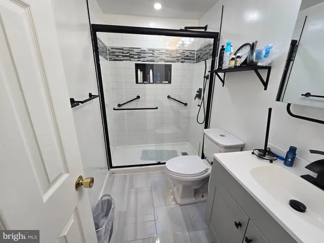 a bathroom with a sink a toilet a mirror and shower