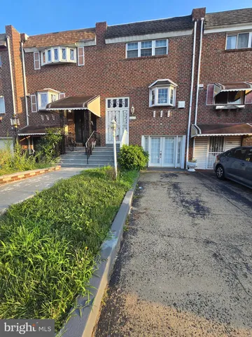 a front view of a house with a yard and potted plants