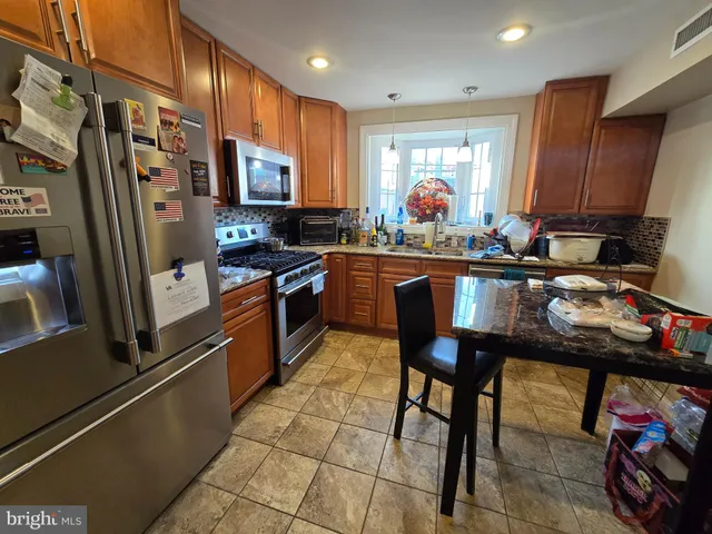 a kitchen with stainless steel appliances granite countertop sink stove refrigerator and cabinets