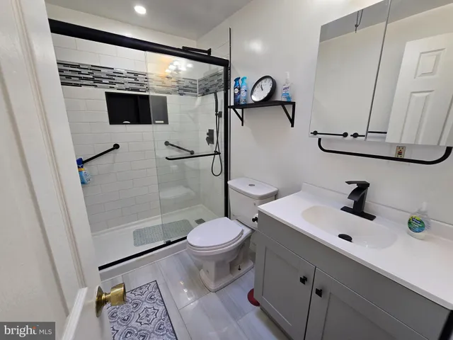 a bathroom with a sink a toilet and shower