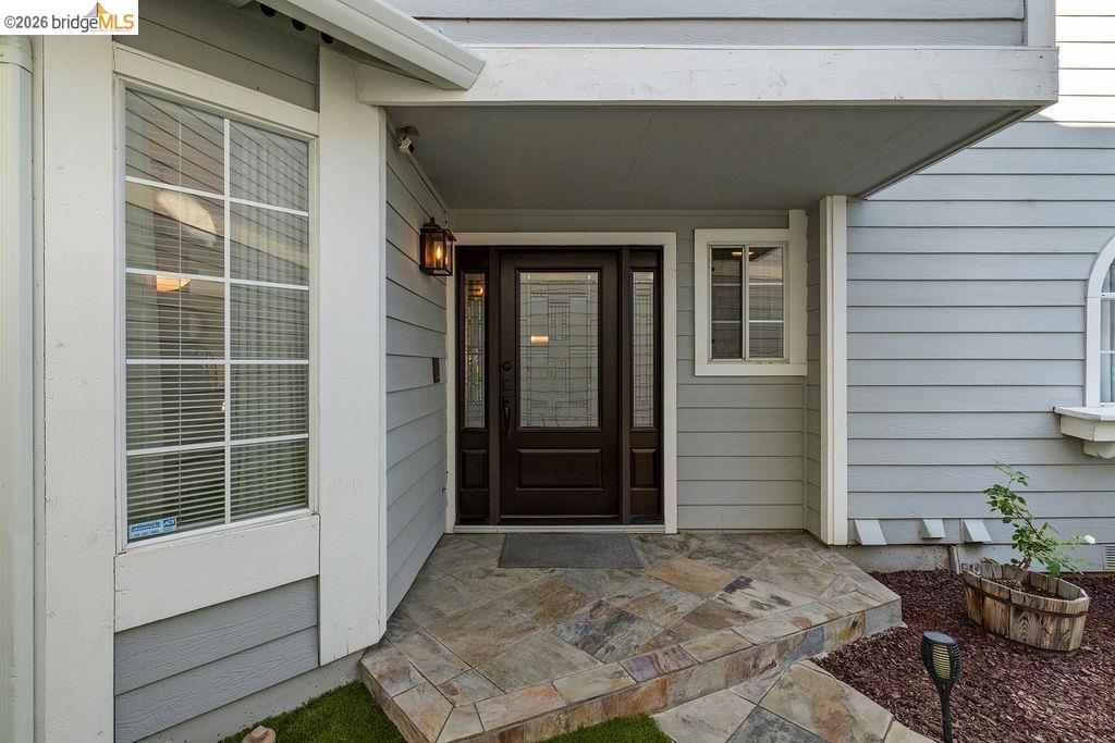 724 Winterside Circle San Ramon, CA 94583 - Photo 3 of 43 Stone tile entryway leading to a dark wood-finish front door with glass sidelights