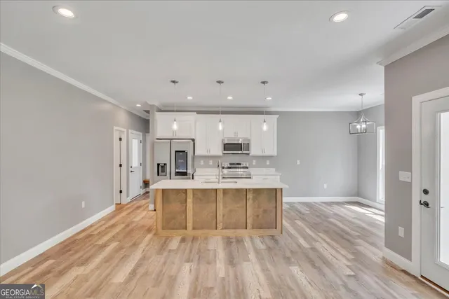 a view of kitchen with wooden floor and electronic appliances