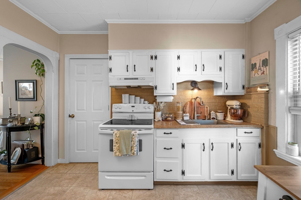 36 Stone Street Beverly, MA 01915 - Photo 11 of 42 a kitchen with white cabinets and clock on the wall