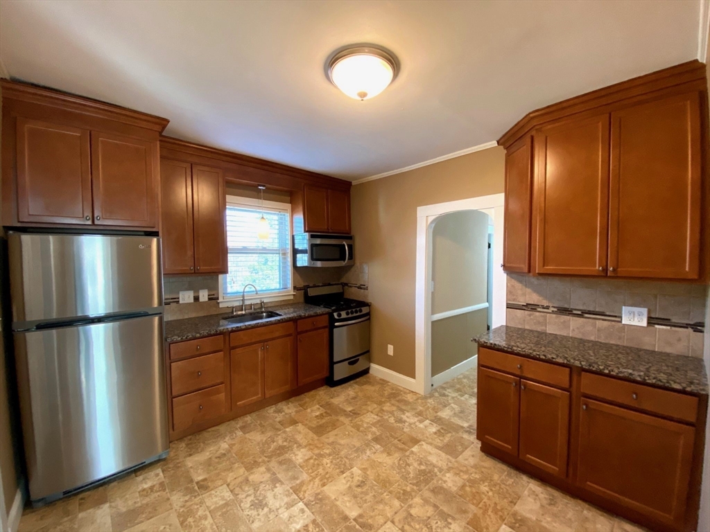 36 Stone Street Beverly, MA 01915 - Photo 22 of 42 a kitchen with stainless steel appliances granite countertop a refrigerator a stove a sink and a microwave