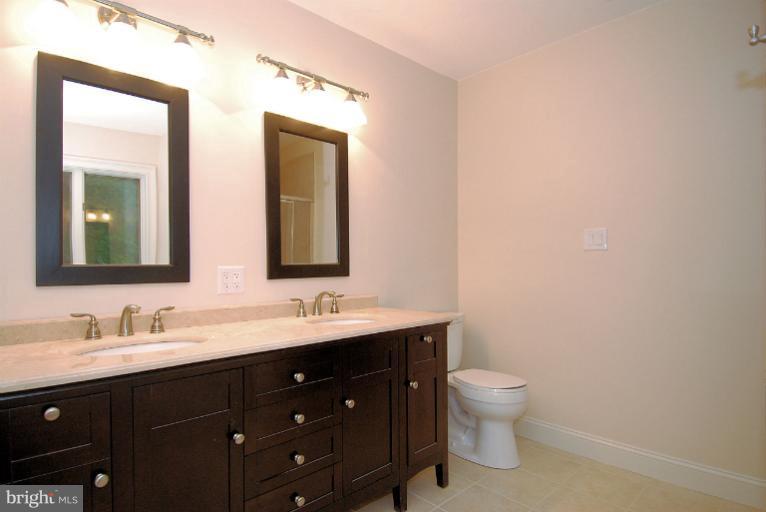 600 Utterback Store Road Great Falls, VA 22066 - Photo 23 of 30 a bathroom with a double vanity sink toilet and mirror