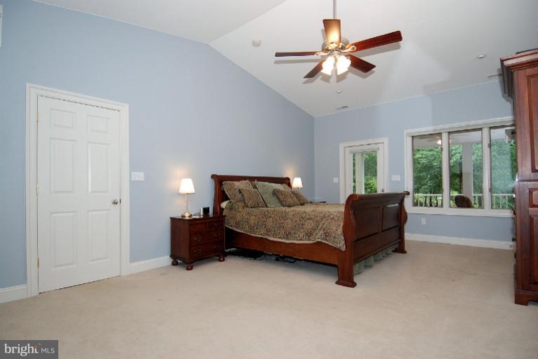 600 Utterback Store Road Great Falls, VA 22066 - Photo 7 of 30 a spacious bedroom with a bed and a chandelier