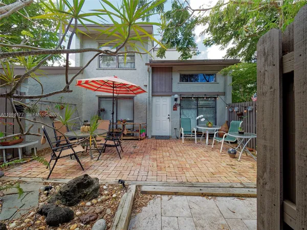 a view of a patio with a table and chairs under an umbrella