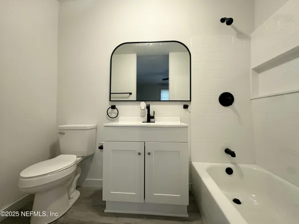 a bathroom with a sink a toilet and mirror