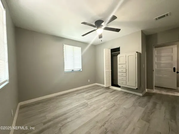 an empty room with closet and windows