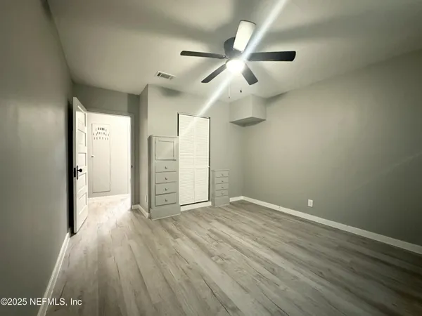 a view of an empty room with wooden floor