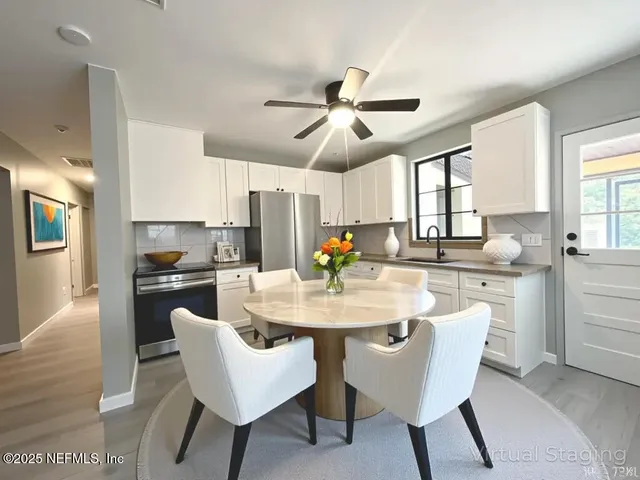 a kitchen with white cabinets and stainless steel appliances