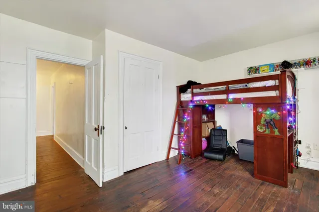 a view of a bedroom with wooden floor and closet