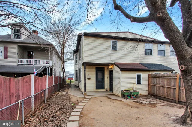 a view of a house with a yard and wooden fence