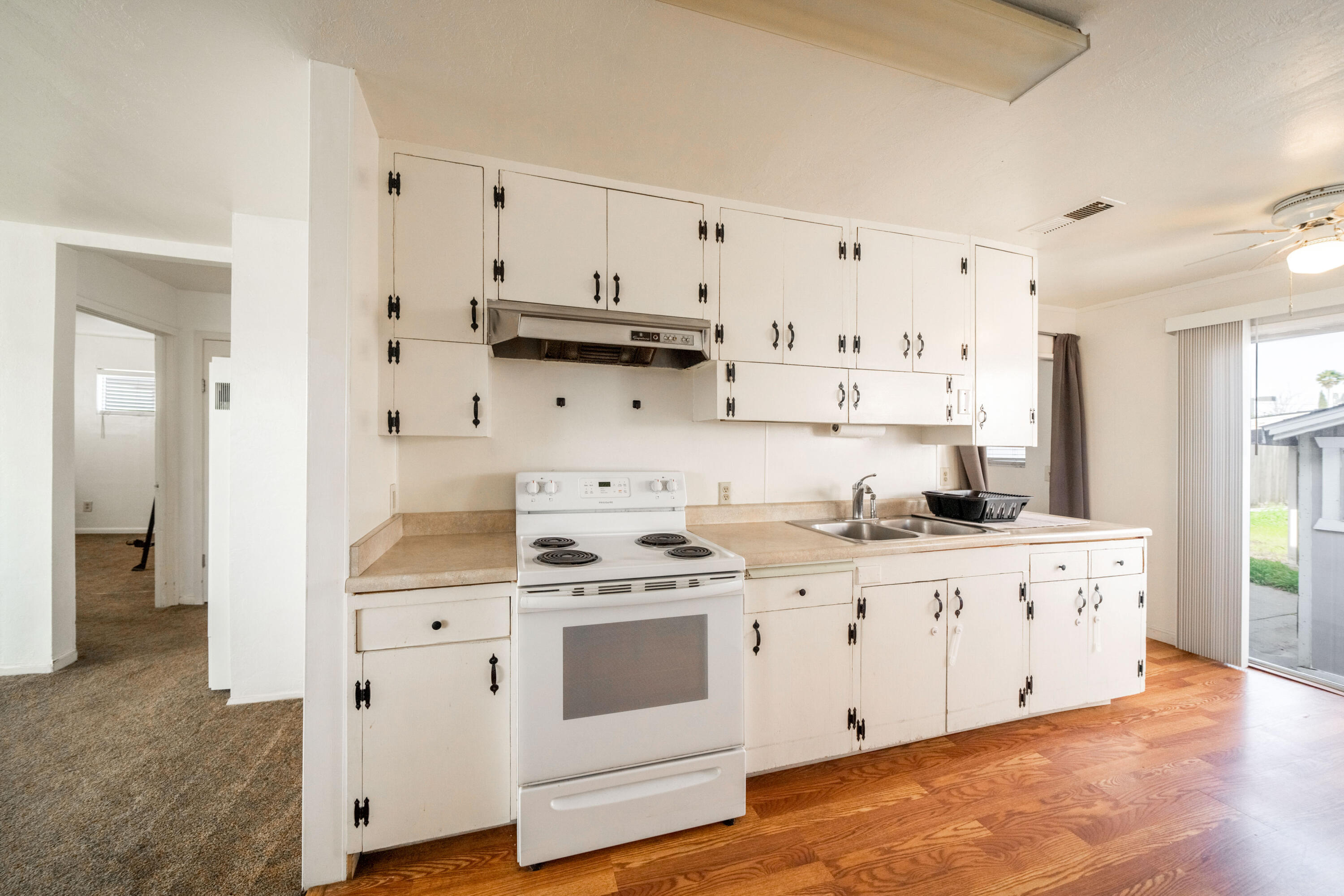 240 Kimball Road Red Bluff, CA 96080 - Photo 11 of 56 a kitchen with stainless steel appliances white cabinets and wooden floors