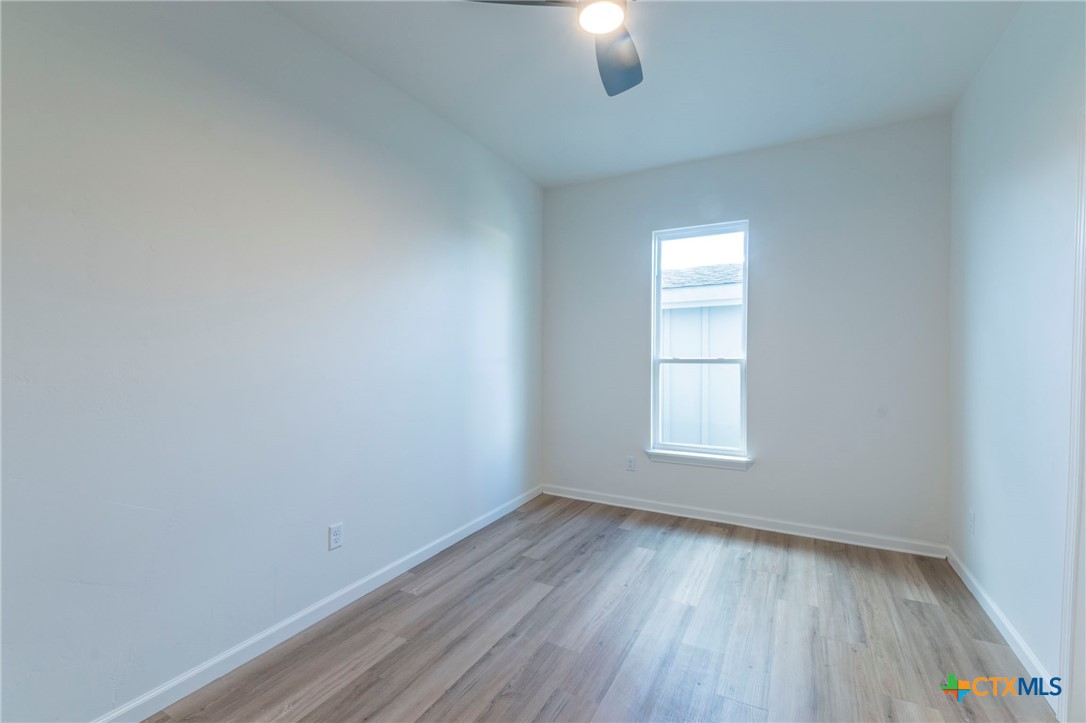 401 South 11th Street Temple, TX 76504 - Photo 17 of 25 an empty room with a window and wooden floor