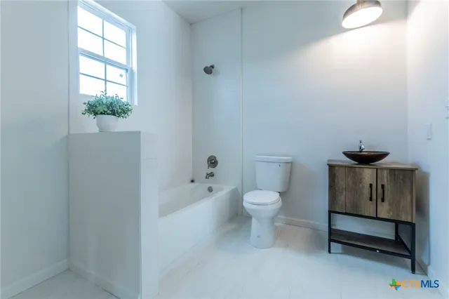a white toilet sitting next to a bath tub