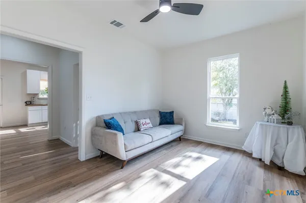 a living room with furniture and a wooden floor