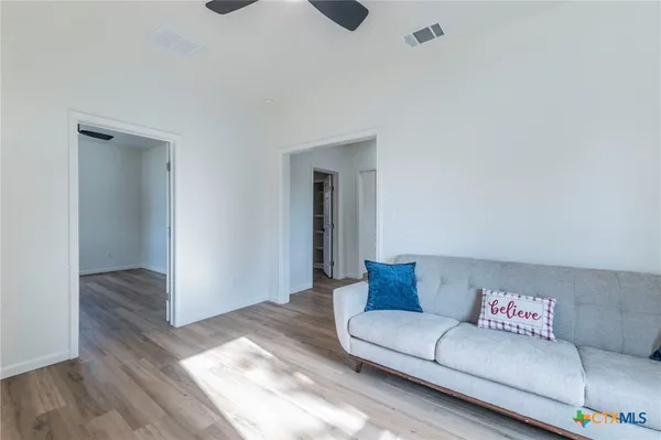 a living room with furniture and a wooden floor