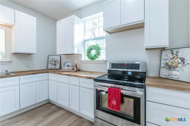 a kitchen with stainless steel appliances a stove a sink and a microwave