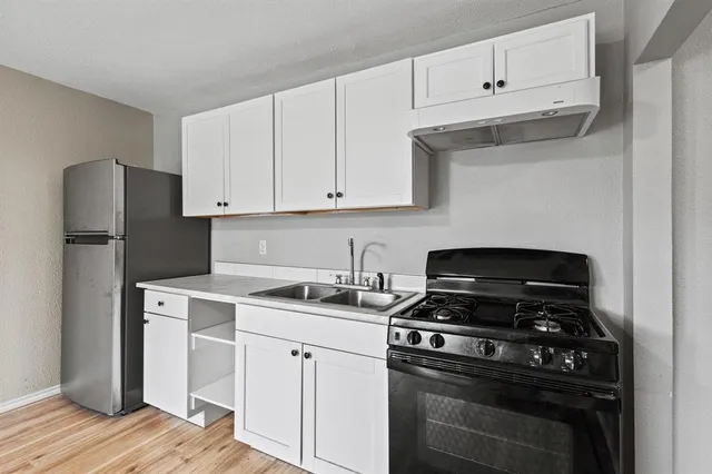 a kitchen with cabinets appliances and a sink