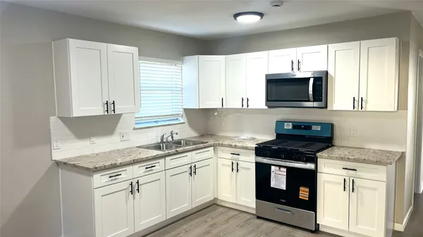 a kitchen with granite countertop a sink and steel appliances