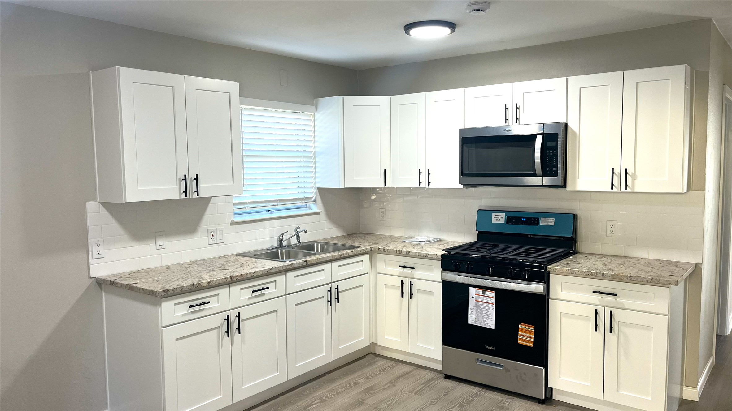 a kitchen with granite countertop a sink and steel appliances