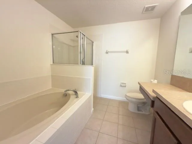a spacious bathroom with a granite countertop sink a toilet and shower