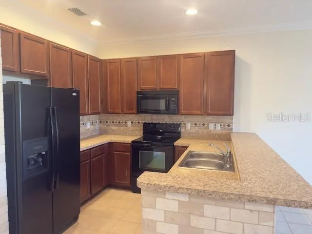 a kitchen with stainless steel appliances granite countertop a refrigerator stove top oven and sink