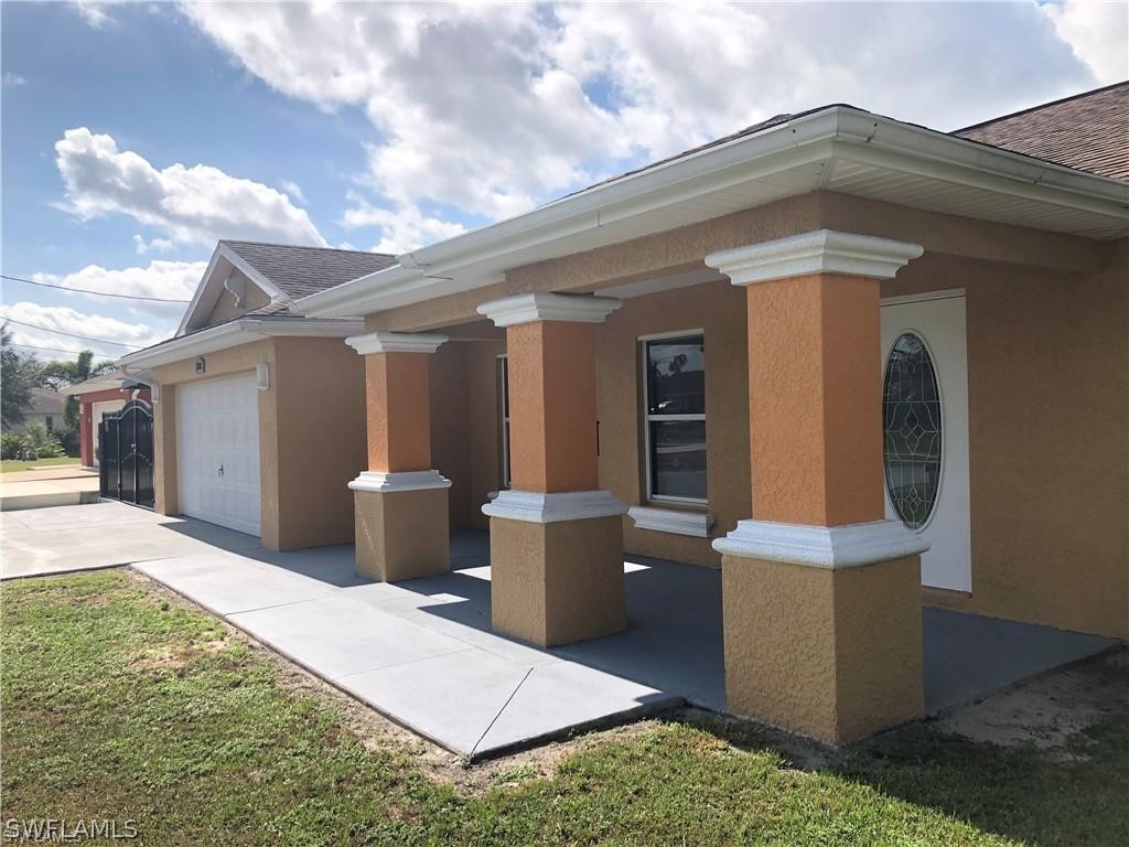636 Homestead Road South Lehigh Acres, FL 33974 - Photo 3 of 30 a backyard of a house with wooden fence and large windows
