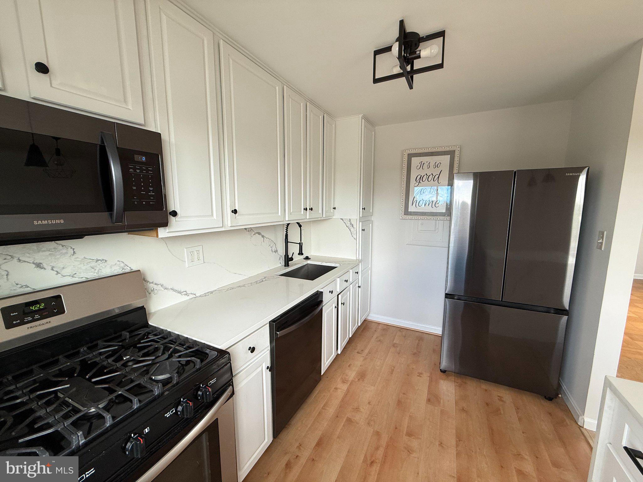 614 Sligo Avenue, Unit 411 Silver Spring, MD 20910 - Photo 11 of 24 a kitchen with a stove a refrigerator and a microwave