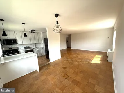 a view of a kitchen with a sink and dishwasher a stove top oven with wooden floor