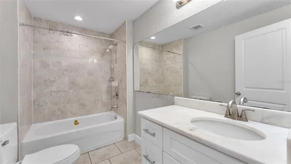 a bathroom with a granite countertop sink a toilet and bathtub