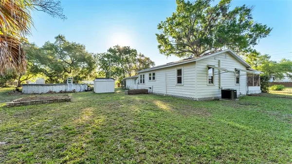 a backyard of a house with a garden and barbeque oven