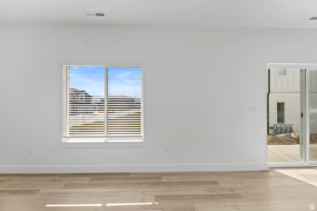 1262 West 500 South Logan, UT 84321 - Photo 8 of 39 Open-concept living space with light wood-finish flooring, white walls, and a large window with horizontal blinds