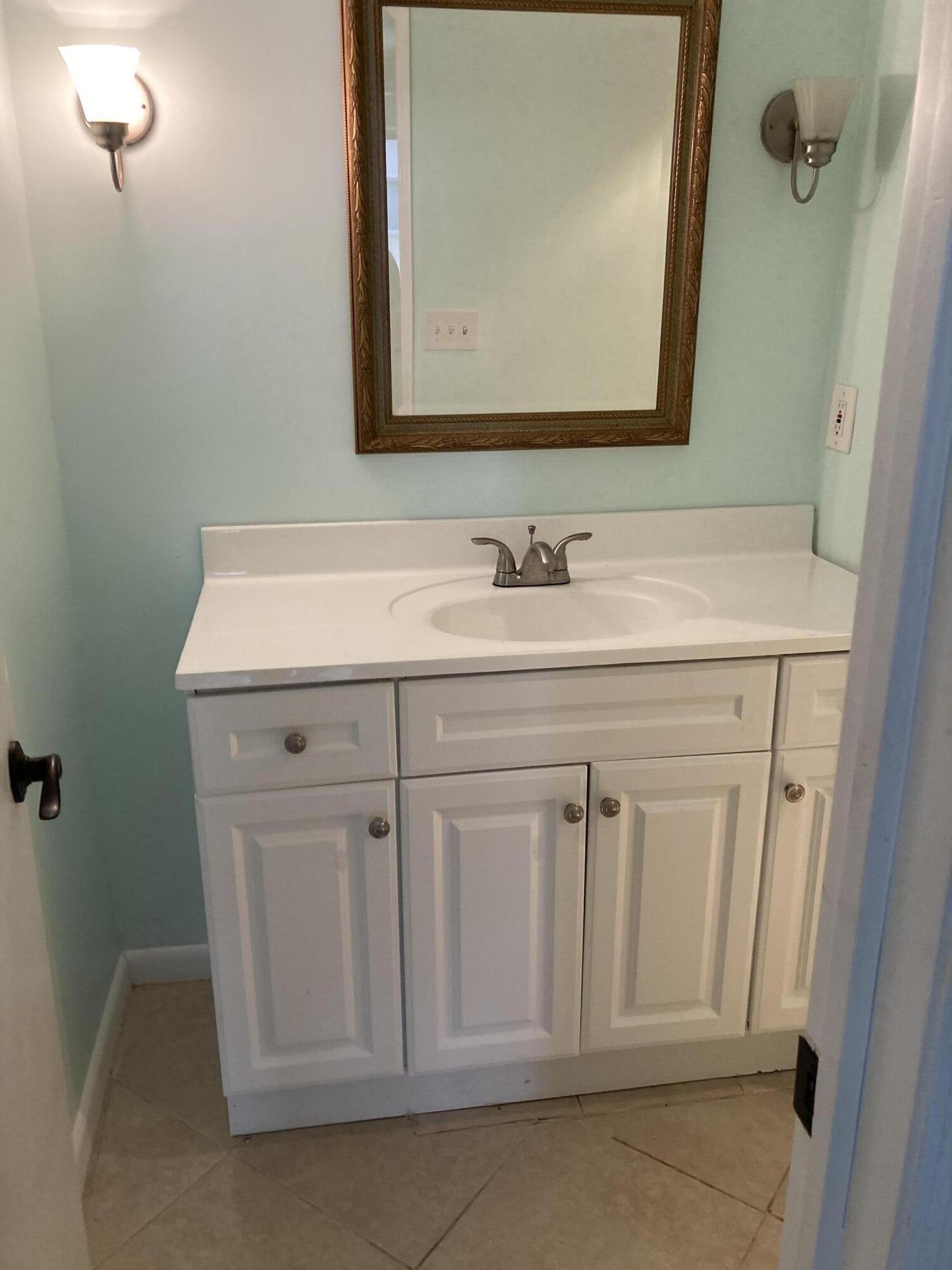 11811 Ave Of The PGA, Unit 21C Palm Beach Gardens, FL 33418 - Photo 12 of 30 a bathroom with a sink a vanity and a mirror