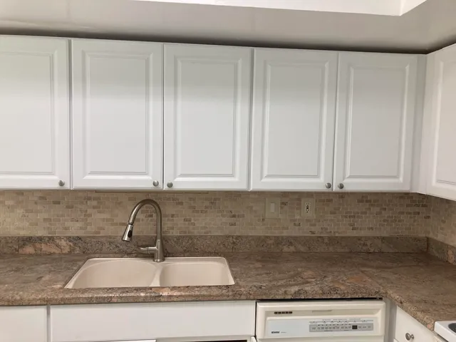 a kitchen with granite countertop a sink and cabinets