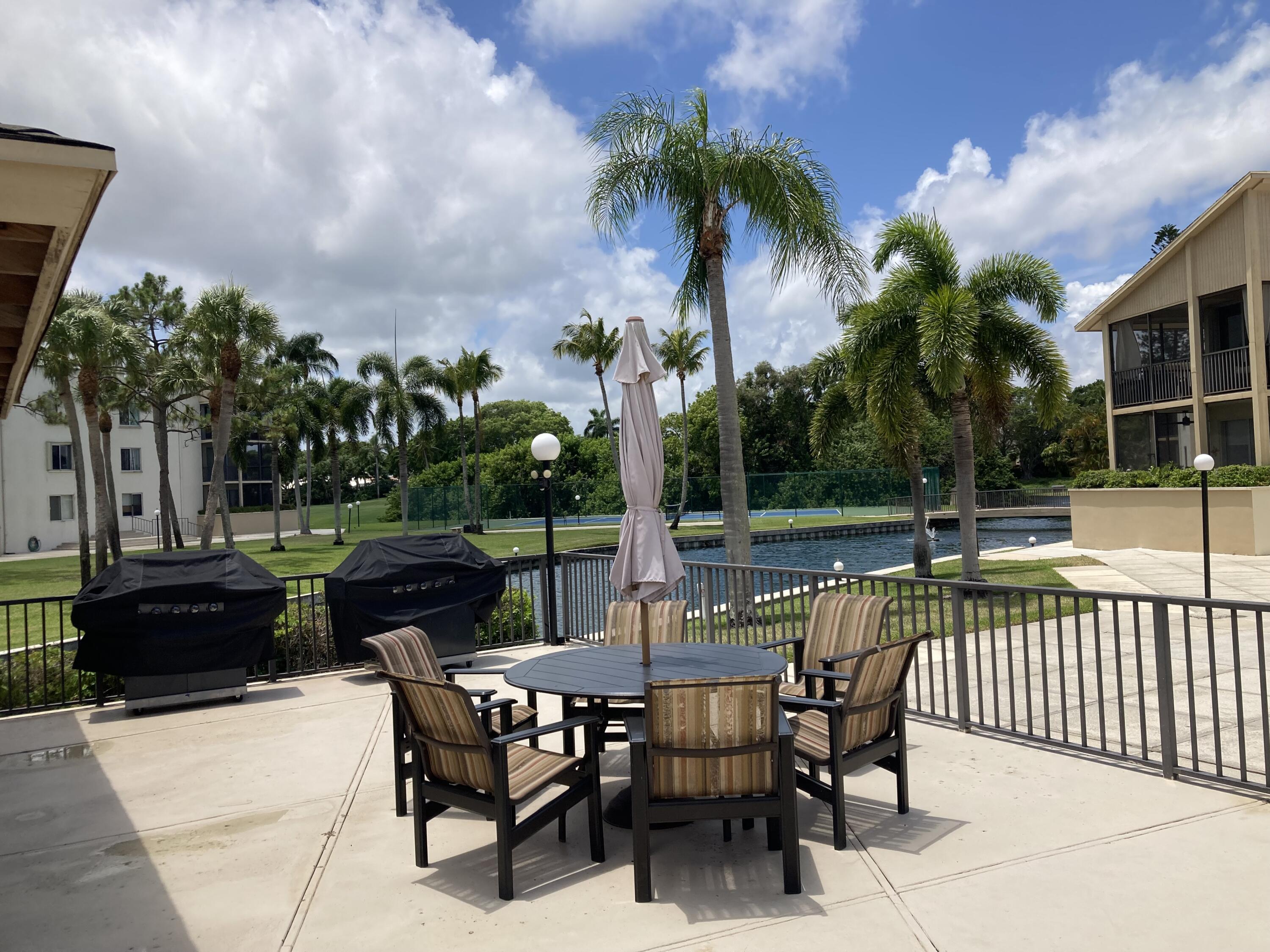 11811 Ave Of The PGA, Unit 21C Palm Beach Gardens, FL 33418 - Photo 5 of 30 a view of a patio with a table and chairs
