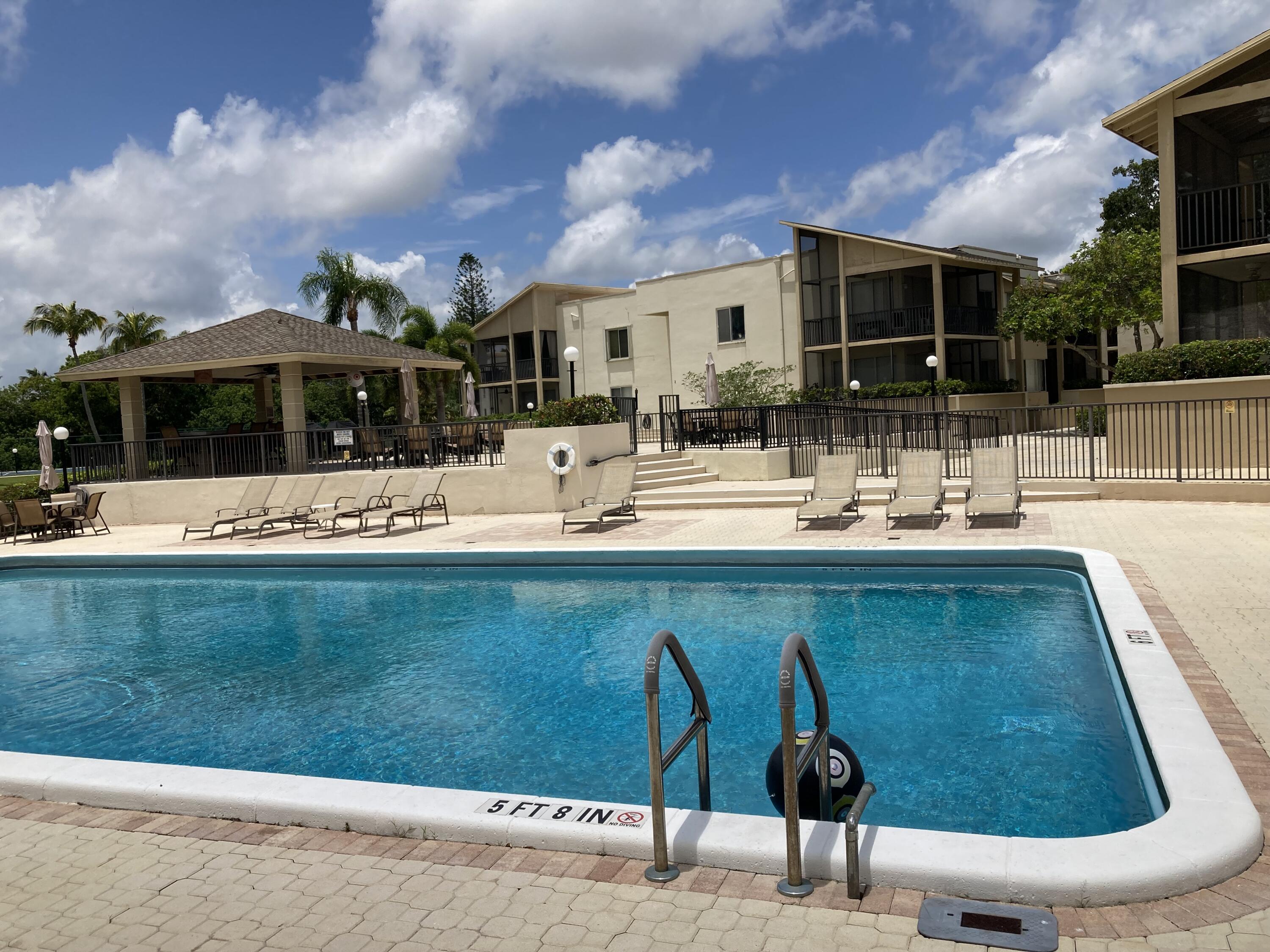 11811 Ave Of The PGA, Unit 21C Palm Beach Gardens, FL 33418 - Photo 9 of 30 a view of a patio with swimming pool table and chairs