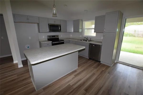 a kitchen with granite countertop a stove and a microwave
