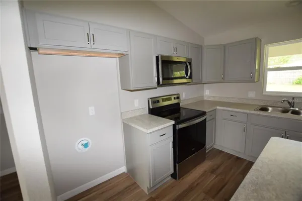a kitchen with a sink stove and cabinets