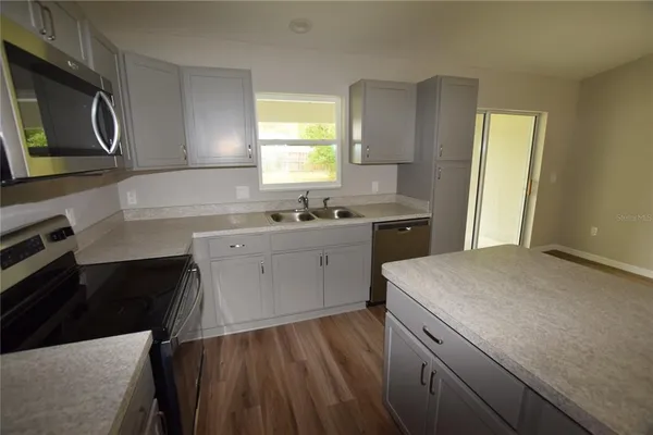 a kitchen with a sink a stove and cabinets