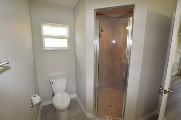 a bathroom with a granite countertop sink toilet and mirror