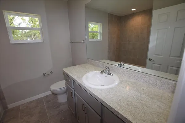 a bath tub sitting next to a white sink and a shower