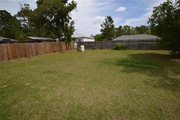 a backyard of a house with lots of green space and plants