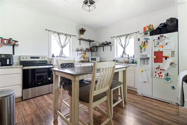 a kitchen with granite countertop a stove a sink and a refrigerator