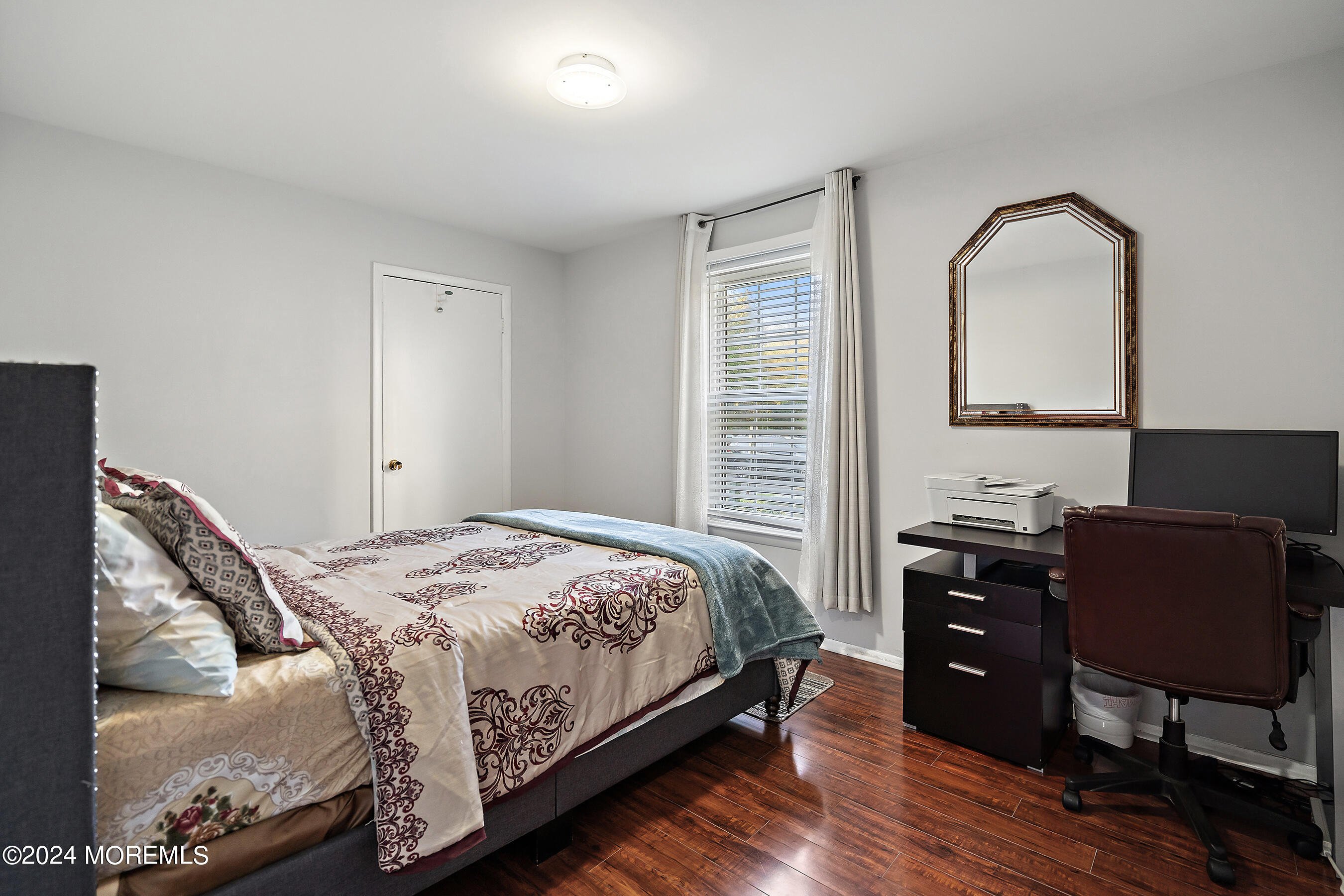 509 Harding Road, Unit 2 Freehold, NJ 07728 - Photo 23 of 24 a bedroom with a bed and dresser with wooden floor