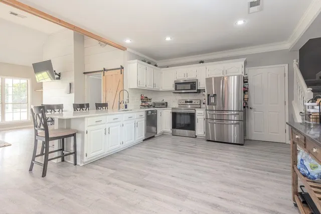 a kitchen with white cabinets and white appliances